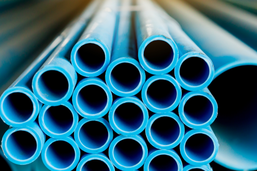 En hög med blåa plaströr i olika storlekar.