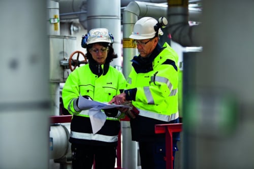 Kiwa eksperdid naine ja mees vaatavad surveseadmete dokumente tehases