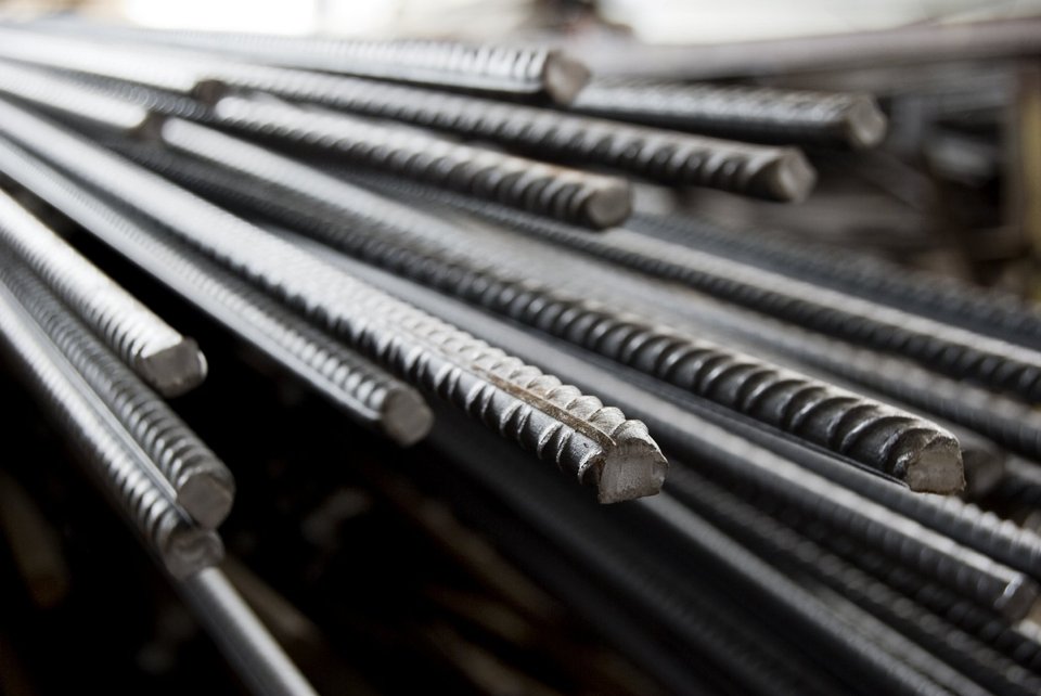 Stapel metalen wapeningsstaven met ribbels, liggend en geordend.