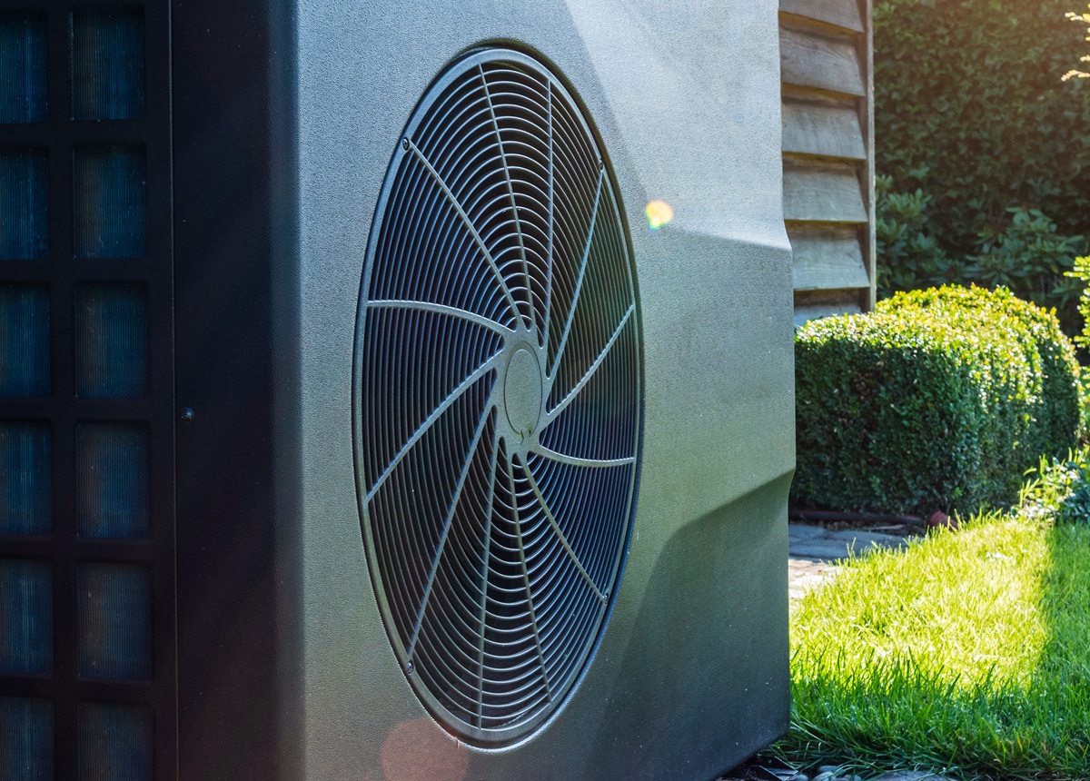 Buitenunit van een warmtepomp aan een muur van een gebouw