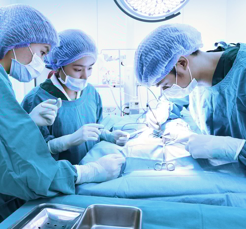 Three doctors performing a surgery