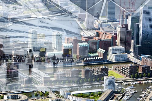 Luchtfoto van een moderne havenstad met hoge kantoorgebouwen, waterwegen en een druk stadscentrum.