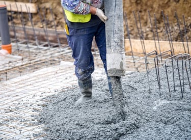 Werknemer die beton aan het storten is