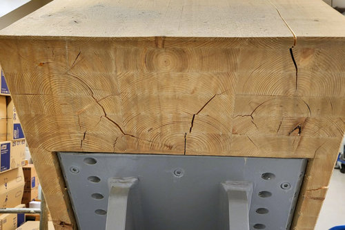 Modern idrottshall med böjda träbalkar i limträ, läktare och ljus takdesign.
