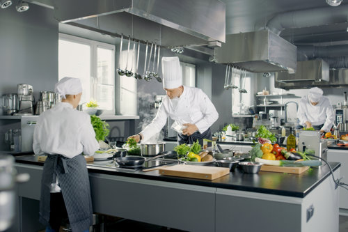 Chefs in a restaurant kitchen which can be auditing by Kiwa